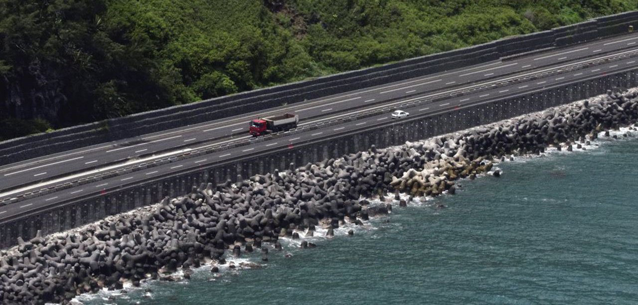 Pour faire la route digue, il faut d'abord combler l'océan, puis monter la route à plus de 10 mètres de hauteur, il faut juste imaginer les tonnes de roches nécessaires... (photo Les Echos)